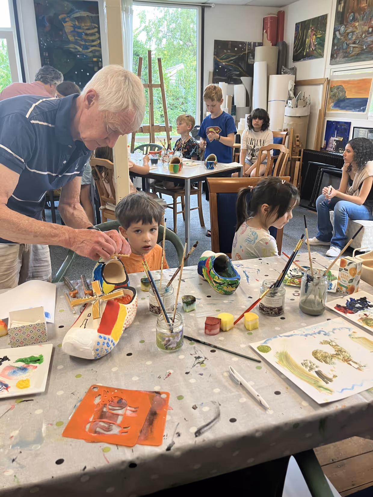 Children painting wooden shoes